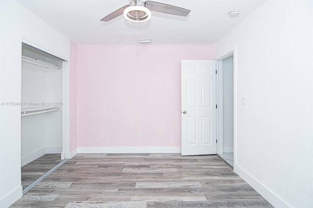 unfurnished bedroom with ceiling fan, light hardwood / wood-style flooring, and a closet