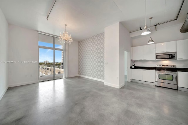 kitchen featuring white cabinetry, appliances with stainless steel finishes, a chandelier, and decorative light fixtures