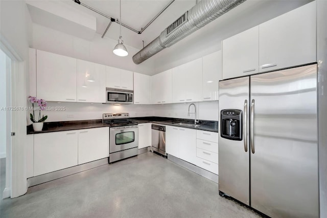 kitchen with white cabinetry, stainless steel appliances, sink, and pendant lighting