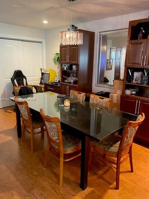 dining area featuring light wood-type flooring and a notable chandelier