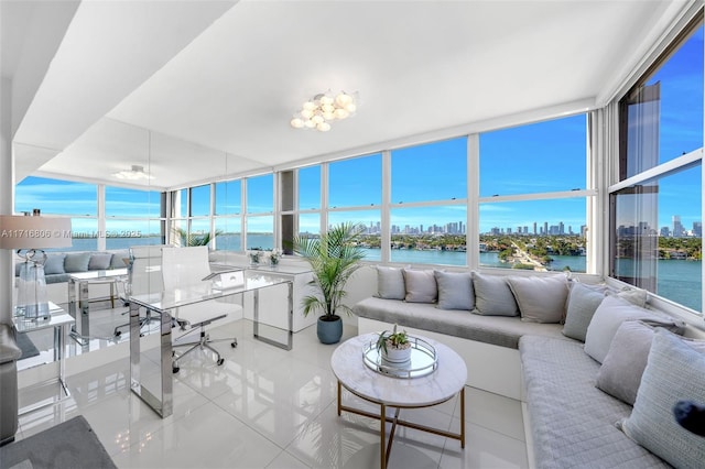 sunroom / solarium featuring a view of city, a healthy amount of sunlight, and a water view