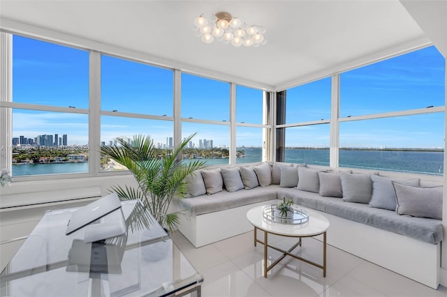 sunroom / solarium with plenty of natural light, a water view, and a city view