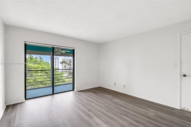 empty room featuring wood-type flooring and a textured ceiling