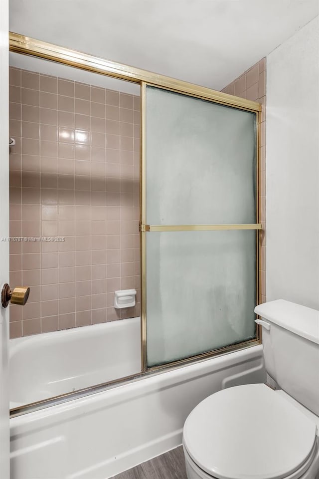 bathroom with toilet, enclosed tub / shower combo, and hardwood / wood-style floors