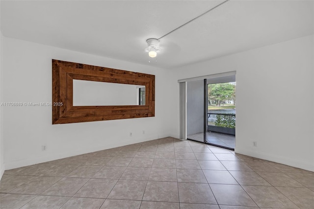 empty room with ceiling fan and light tile patterned floors