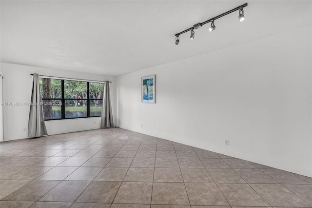 empty room with rail lighting and light tile patterned floors