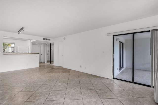 unfurnished living room featuring rail lighting and light tile patterned floors