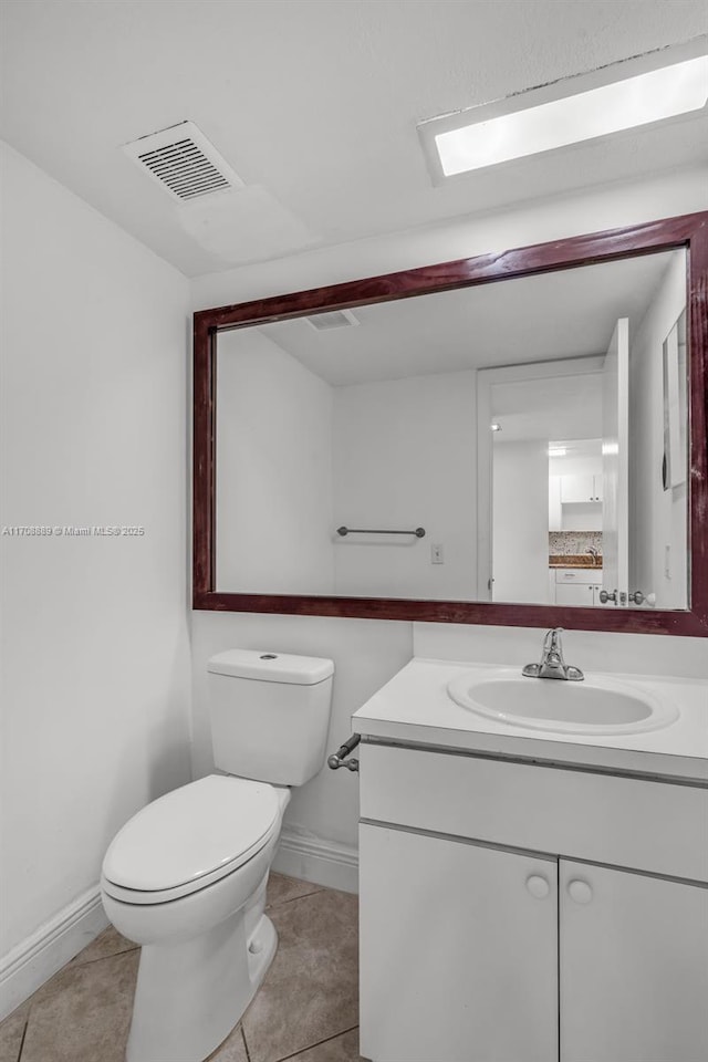 bathroom featuring toilet, tile patterned flooring, and vanity