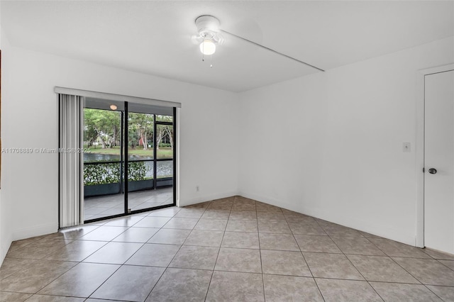 tiled spare room with ceiling fan