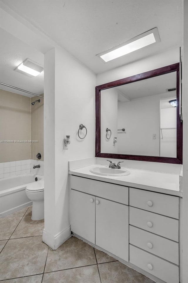 full bathroom with tile patterned flooring, tiled shower / bath combo, vanity, and toilet