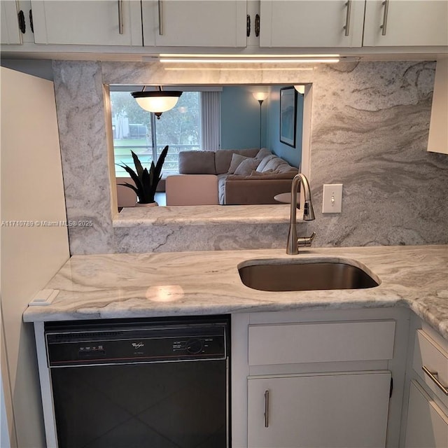 kitchen with white cabinetry, light stone countertops, dishwasher, and sink