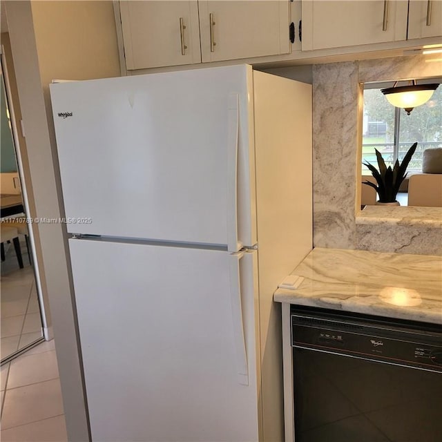 kitchen with white fridge, dishwasher, light stone countertops, and light tile patterned floors