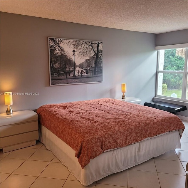 bedroom with a textured ceiling and light tile patterned floors