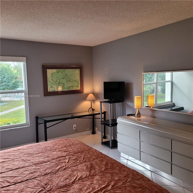 bedroom with a textured ceiling and light tile patterned floors