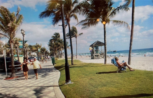 view of community featuring a yard, a beach view, and a water view