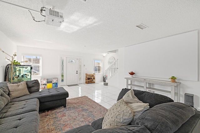 tiled living room featuring a textured ceiling