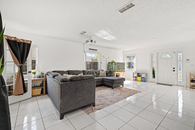 living room featuring a textured ceiling and light tile patterned flooring