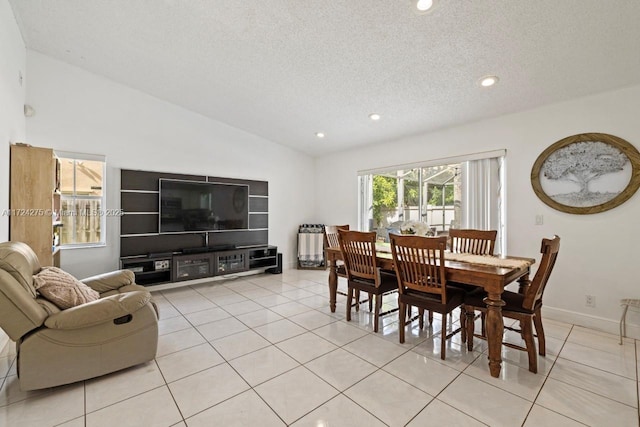 dining room featuring lofted ceiling, a textured ceiling, and light tile patterned floors