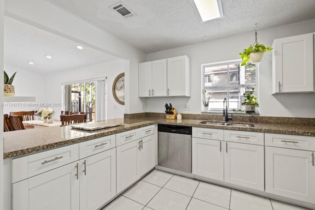 kitchen featuring sink, white cabinets, dishwasher, and kitchen peninsula