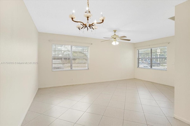 empty room with ceiling fan with notable chandelier and light tile patterned floors