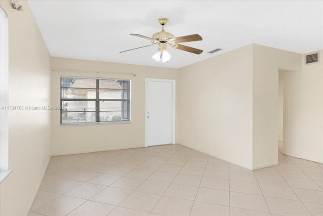 empty room with ceiling fan and light tile patterned floors