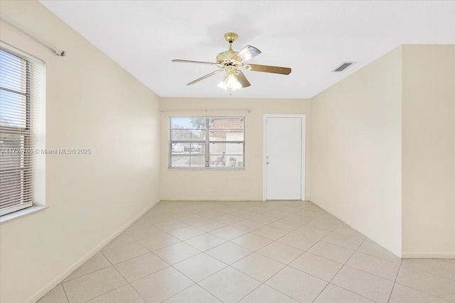 tiled empty room featuring a healthy amount of sunlight and ceiling fan