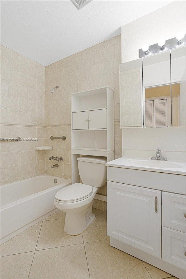 full bathroom with toilet, tile patterned flooring, tiled shower / bath, and vanity