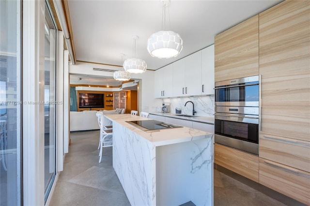 kitchen featuring a kitchen island with sink, hanging light fixtures, double oven, black electric cooktop, and white cabinets