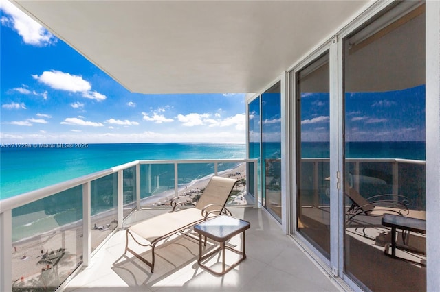 balcony featuring a view of the beach and a water view