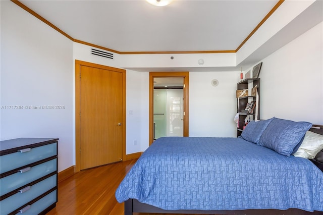 bedroom featuring hardwood / wood-style floors and crown molding