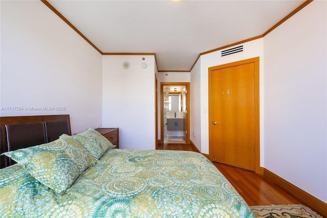 bedroom featuring ornamental molding and wood-type flooring