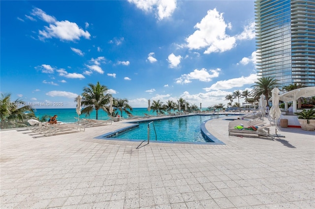 view of swimming pool featuring a patio area and a water view