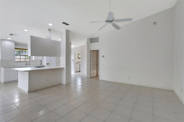 kitchen with white fridge with ice dispenser, white cabinets, vaulted ceiling, ceiling fan, and light tile patterned floors