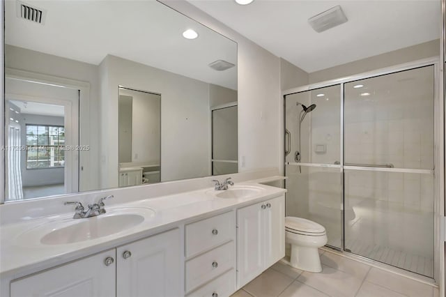 bathroom featuring toilet, a shower with door, tile patterned floors, and vanity