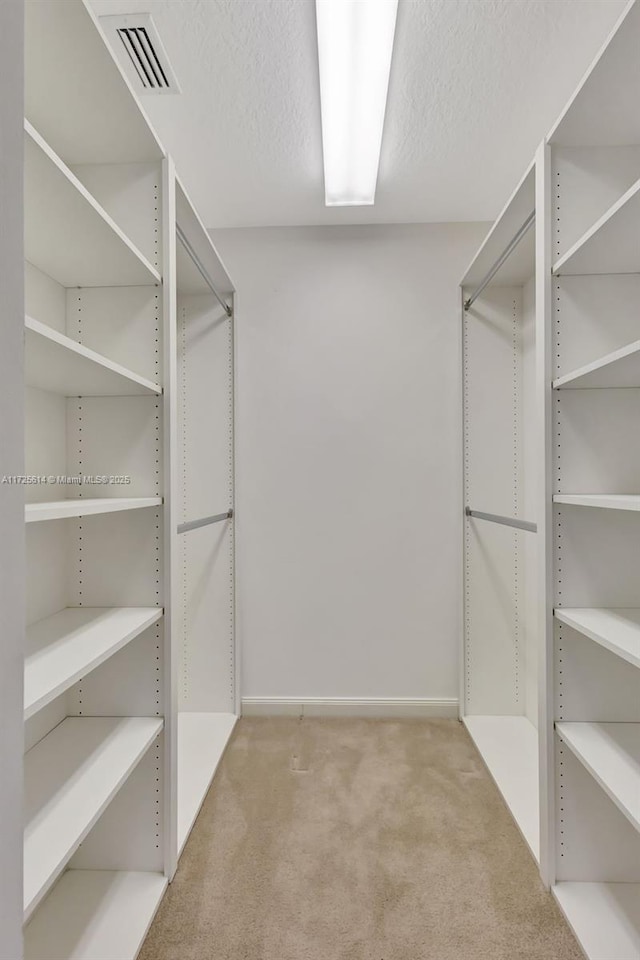 walk in closet featuring light carpet