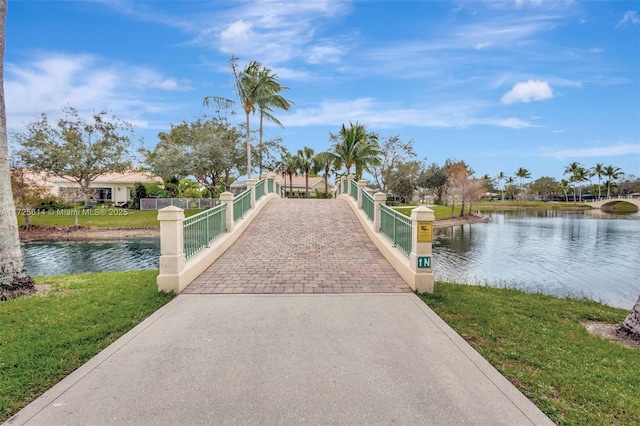 view of property's community with a lawn and a water view