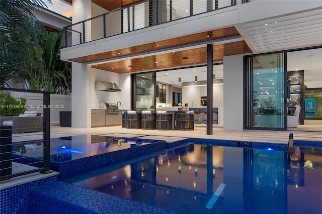 view of pool with an in ground hot tub, an outdoor kitchen, and a patio