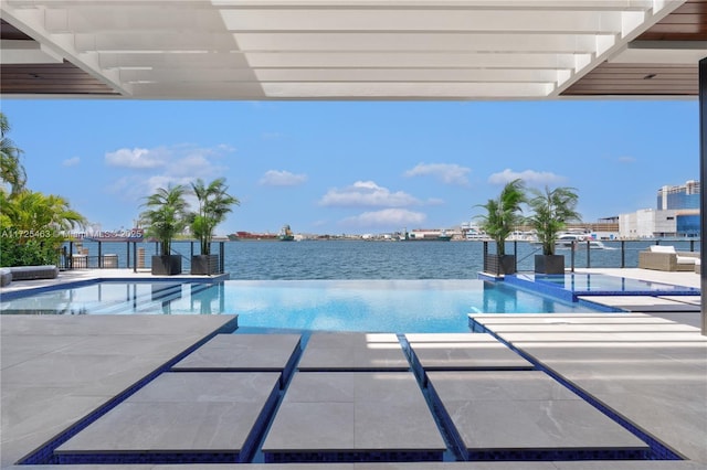 view of pool with a water view and a patio area