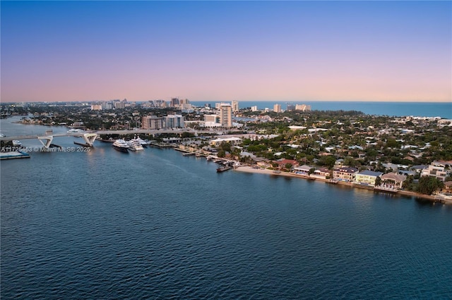 aerial view at dusk featuring a water view