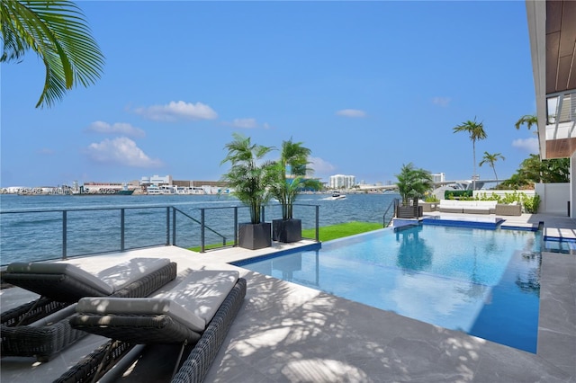 view of swimming pool with a patio and a water view