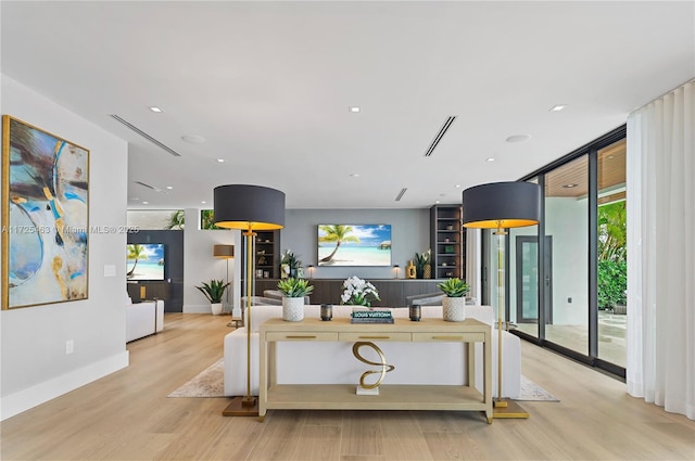 living room with a wall of windows and light hardwood / wood-style floors