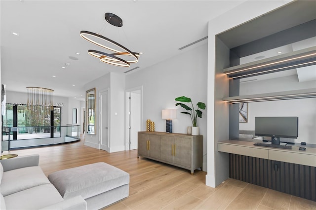 living room with a notable chandelier and light wood-type flooring