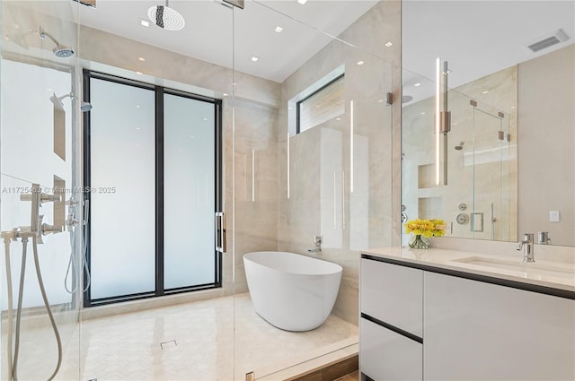 bathroom with vanity, tile walls, and separate shower and tub