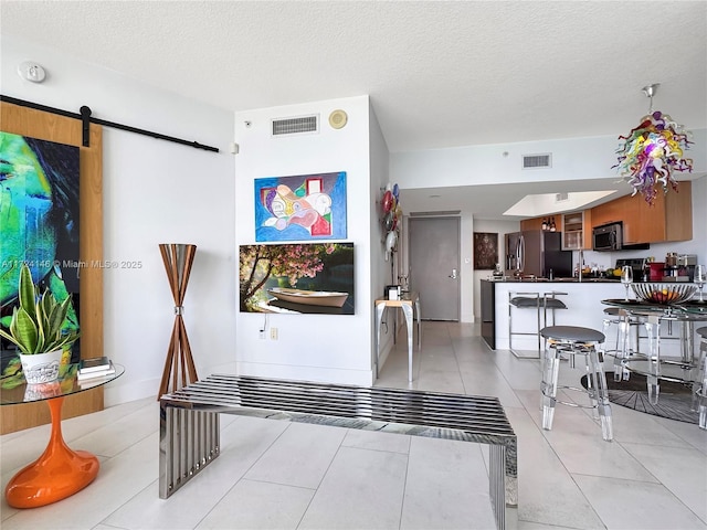 interior space featuring a barn door and a textured ceiling