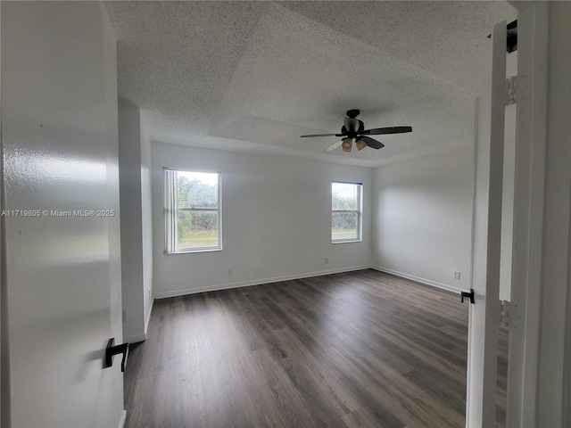 spare room with dark wood-type flooring, a textured ceiling, and ceiling fan