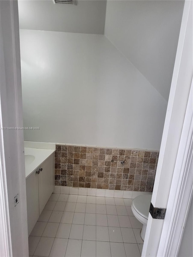 bathroom with toilet, tile patterned floors, and vanity