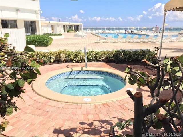 view of swimming pool with a community hot tub and a water view