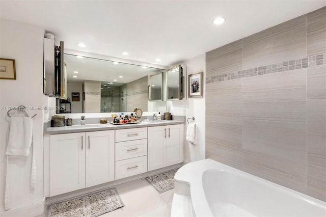 bathroom featuring tile walls, vanity, tile patterned floors, and plus walk in shower