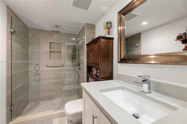 bathroom with toilet, a shower with door, and vanity