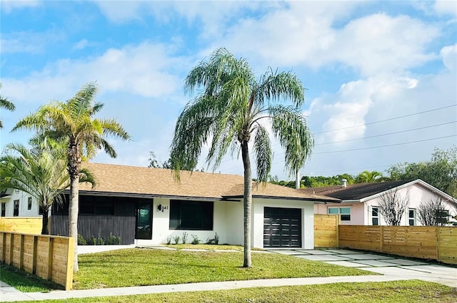 ranch-style home with a garage and a front yard